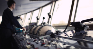 Navigation officer driving ship on the river.